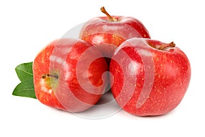 three red apples with green leaves isolated on white background