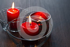 Three red candles in close-up. Home decor items. Bright light of burning candles