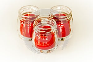 Three red candles in little glass vases