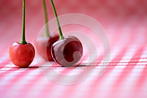 Three red cherries on a table
