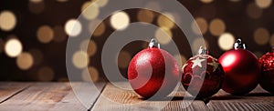 three red christmas balls sit next to each other on a wooden table
