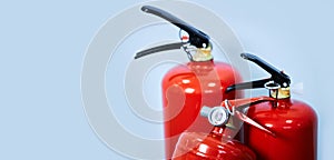 Three red fire extinguishers on a blue background