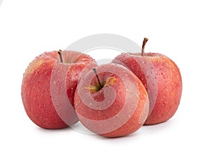 Three red fuji apples in water drops on a white isolated background