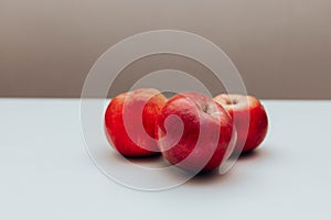 Three red juicy apples on white table. Space for text photo
