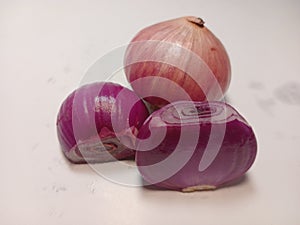 three red onions on a white background