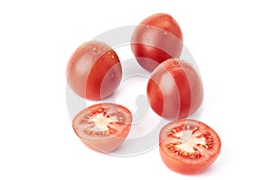 Three red ripe tomatoes soaked in water together with a tomato cut in half. Organic food