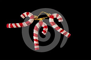 Three red striped Santa candies are stacked on a black background. To isolate the framing. Christmas toys for Christmas