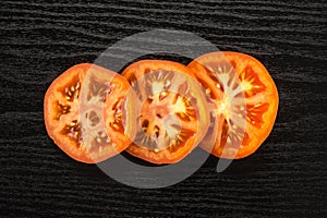 Fresco crudo tomate variedad sobre el negro madera 