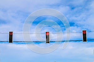 Three red traffic lights hang over the road against the blue sky. Prohibition signal.