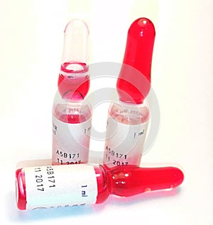 Three red vials of medicine