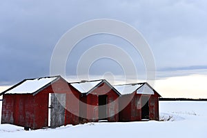 Three Red Wooden Grain Storage Sheds