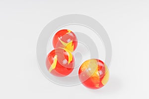 Three red yellow marbles isolated on white