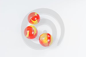 Three red yellow marbles on white