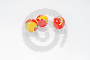 Three red yellow marbles on white