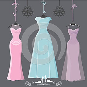 Three retro long bridesmaid dresses hang on