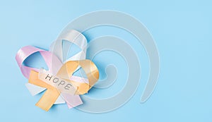 Three ribbons with the word hope on a blue background.