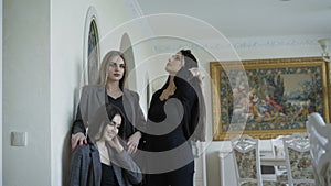 Three rich models posing in brand clothes in luxurous apartment