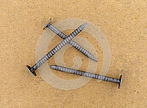 Three ring shank underlayment nails on a cardboard surface photo