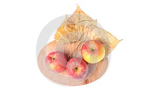 Three ripe apples, fallen leaves