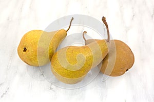 Three ripe bosc pears on cutting board