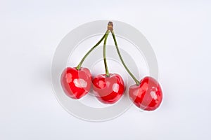 Three ripe cherries isolated on white.