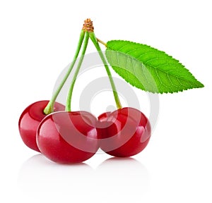 Three ripe cherries with leaf isolated on white background