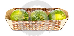 Three ripe limes in cardboard container isolated on white background