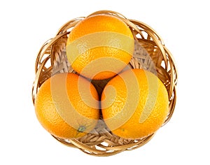 Three ripe oranges in wicker basket isolated on white