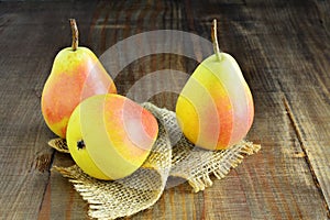 Three ripe pears over wooden table.