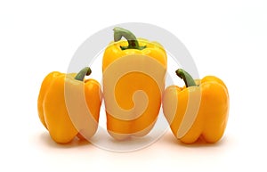 Three ripe sweet peppers of yellow color on a light background.