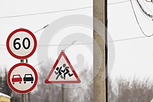 three road signs stand together. a sign overtaking is forbidden, the speed restriction sign. sign caution children