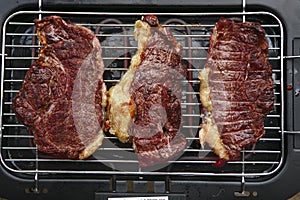 Three roast steak on electrical brazier photo