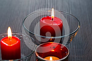Three romantic candles in close-up. Home decor items. The light of the fire of paraffin candles