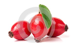 Three rose hip berry with leaf isolated on white background