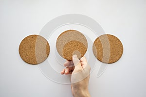 Three round cork board and hand selecting the middle