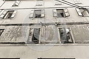 Three row of old windows in grungy exterior wall