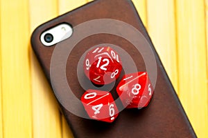 Three RPG polyhedral game dice, dice set laying on a modern smartphone. Role playing games, mobile phone apps for roleplay photo