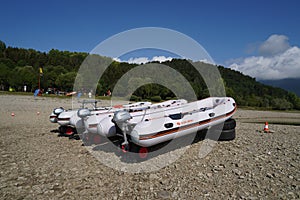 Three rubber dinghy or boats with overboard suspended motor.