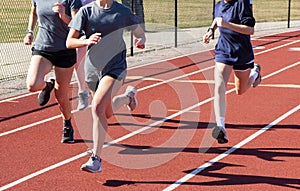 Three runners running fast in lanes on a track