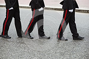 Three Russian cadets in a ceremonial black uniform go one after another. Crop by waist. People in uniform. photo