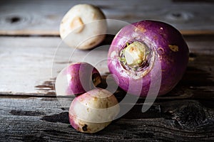 Three rutabaga lying on rustic wood background.