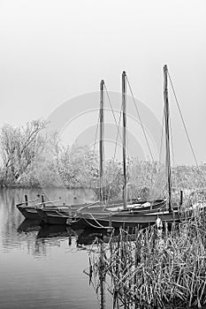 Three sailing boats in a misty cold landscape BW