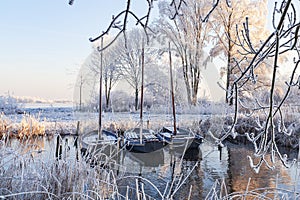 Three sailing boats in a winter landscape