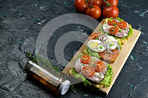 Three Sandwich with ham and tomatoes on wooden board