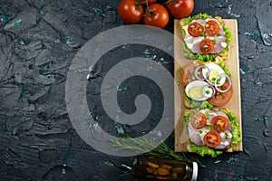 Three Sandwich with ham and tomatoes on wooden board