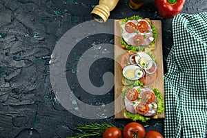 Three Sandwich with ham and tomatoes on wooden board
