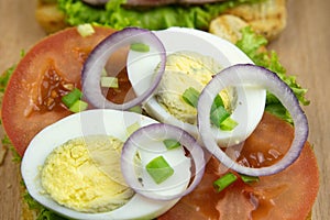 Three Sandwich with ham and tomatoes on wooden board