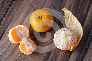 Three satsuma oranges on a rustic wood table