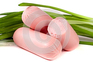 Three sausages with spring onions isolated on white background closeup