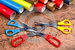 Three scissors with wrapping paper rolls